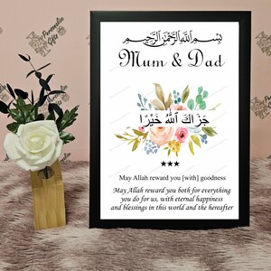 May include: A framed print with a floral design and the Arabic text "بسم الله الرحمن الرحيم" and "جَزَاكَ اللَّهُ خَيْرًا". The text "Mum & Dad" is written below the floral design. The text "May Allah reward you [with] goodness May Allah reward you both for everything you do for us, with eternal happiness and blessings in this world and the hereafter" is written below the Arabic text.