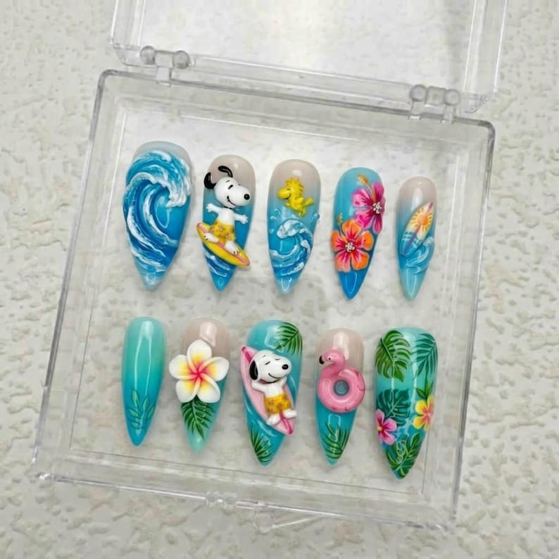 May include: A set of ten artificial nails with a summer theme. Designs include ocean waves, Snoopy surfing, tropical flowers, and a flamingo float. The nails are in a clear plastic case.