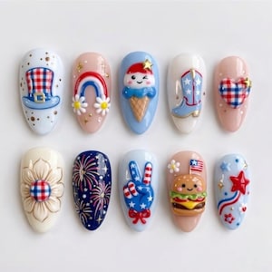 May include: A set of ten almond-shaped press-on nails featuring 3D designs including a plaid top hat, rainbow, ice cream cone, cowboy boot, heart, flower, fireworks, peace sign, hamburger with a flag, and a red star on a light blue background.