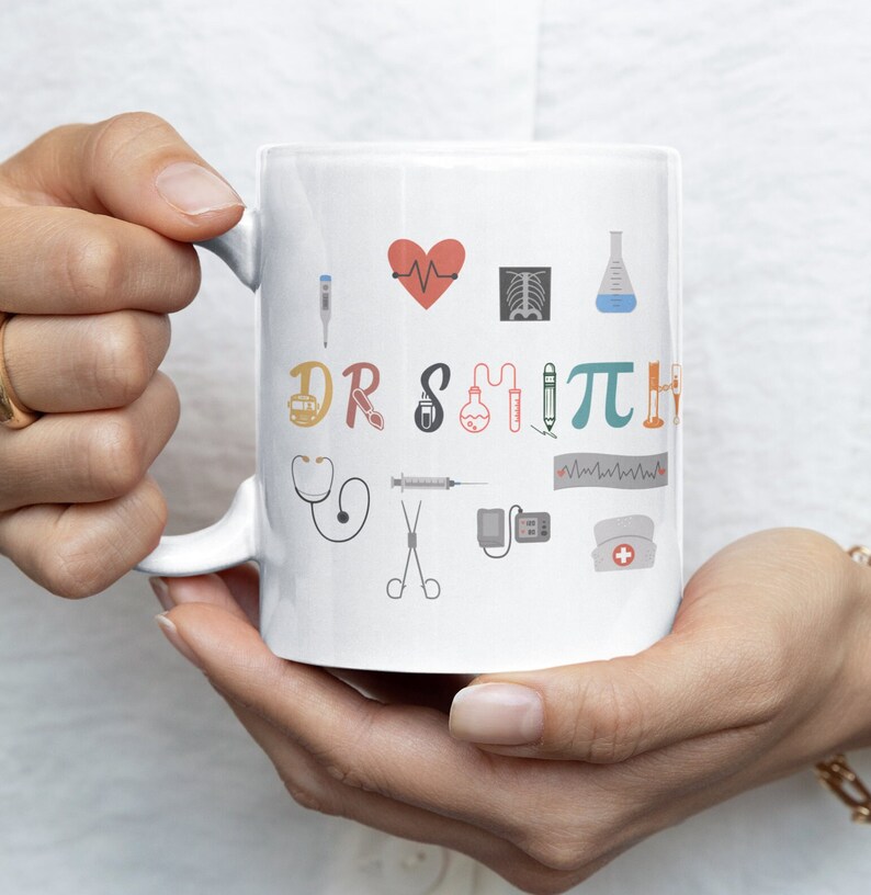 May include: White ceramic mug with a colorful design featuring medical symbols and the text "I &hearts; DR SMITH".
