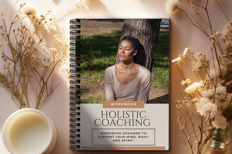 May include: A workbook titled "Holistic Coaching" with the subtitle "Workbook designed to support your mind, body, and spirit." The cover features a woman with her eyes closed, sitting under a tree in a forest.