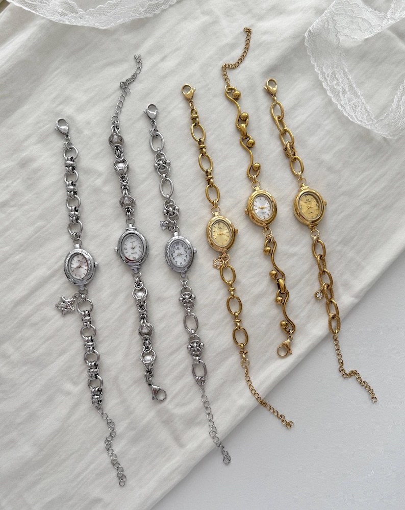 May include: Six delicate wristwatches with oval faces and chain-link bands. Three are silver-toned, and three are gold-toned. The watch faces have Roman numerals. The watches are displayed on a white surface.