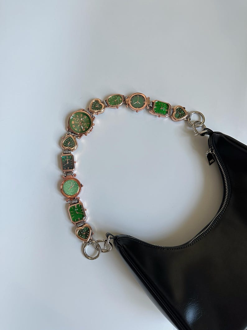 May include: A black leather handbag with a chain strap made of multiple small green and gold watches.