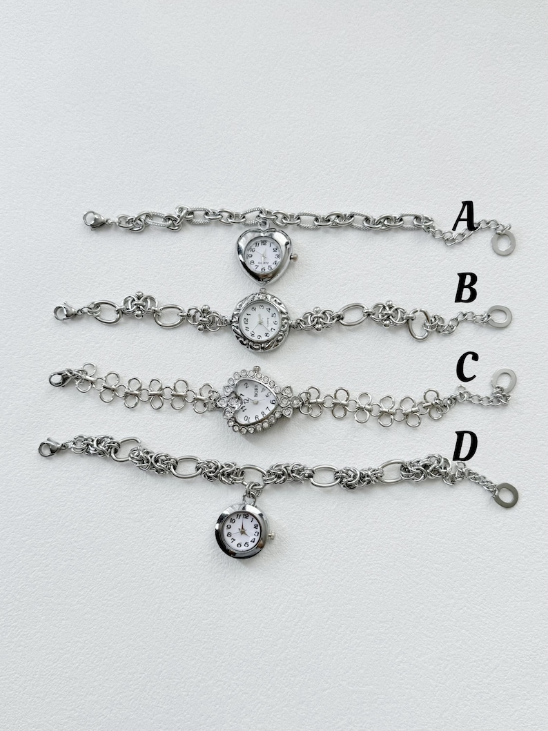 May include: Four silver wristwatches with different chain styles. The watches have round and heart-shaped faces with white backgrounds and black numbers. The watches are arranged vertically with the letter A, B, C, and D next to each watch.