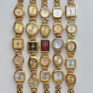 Pode incluir: Uma coleção de 18 relógios de pulso dourados com diferentes designs de mostrador. Os relógios têm uma pulseira de elos.
