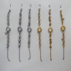 May include: Six bracelet watches with oval faces and different chain styles. The watches are silver and gold-toned, some with charms and dangling chains. The watch faces have a classic, minimalist design, suitable for a range of styles.