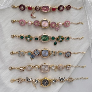 May include: A collection of six ornate, gold-toned bracelet watches. Each watch features a unique design with various colored watch faces, including pink, green, and gold. Embellishments include flowers, bows, and gemstones, creating a delicate and feminine aesthetic.