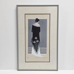 Könnte beinhalten: Ein gerahmter Kunstdruck mit dem Titel The Toast, der eine stilisierte Illustration einer Person von hinten zeigt, die ein langes schwarzes Kleidungsstück mit lavendelfarbenem Kragen und weißem Blumenmuster am Saum vor grauem Hintergrund trägt.