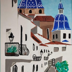 Könnte beinhalten: Acrylbild einer europäischen Dorfansicht. Weiße Gebäude mit roten Ziegeldächern säumen eine schmale Straße. Zwei blau gekuppelte Strukturen mit Kreuzen sitzen auf den Gebäuden. Schwarze schmiedeeiserne Balkone und Straßenlaternen.