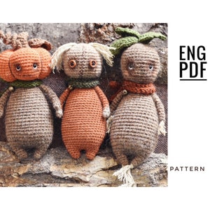 May include: Three crocheted amigurumi toys: a pumpkin, a carrot, and a brown gnome. The toys are all brown and orange with black eyes and mouths. The toys are sitting on a piece of tree bark. ENG PDF PATTERN