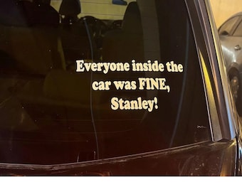 Puede incluir: Una pegatina de vinilo blanco en la ventana trasera de un coche negro dice "Todos dentro del coche estaban BIEN, Stanley!"