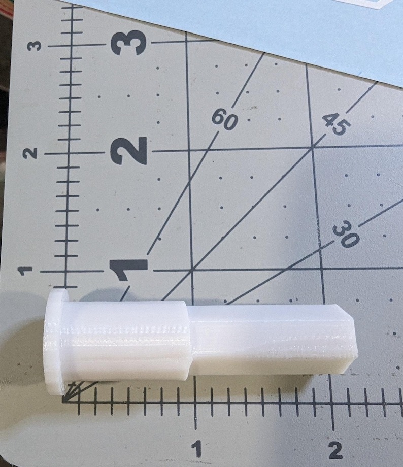 Puede incluir: Un conector de pl&aacute;stico blanco con forma cil&iacute;ndrica y un extremo ligeramente inclinado. El conector mide aproximadamente 5 cm de largo.