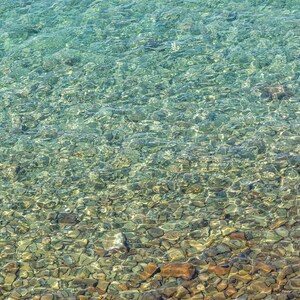 デスクトップの背景: 浜辺の澄んだ水と小石