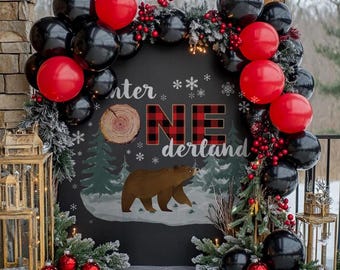May include: A black and red balloon arch with a chalkboard backdrop featuring a bear, trees, and the text "Winter One Derland".
