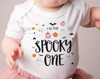 May include: White baby onesie with a black and white graphic that says "I'm the Spooky One" with ghosts, pumpkins, bats, and candy corn.