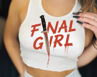 May include: White ribbed crop top with the words "FINAL GIRL" in red, featuring a knife graphic. The knife appears to be dripping with red blood. The top is sleeveless.