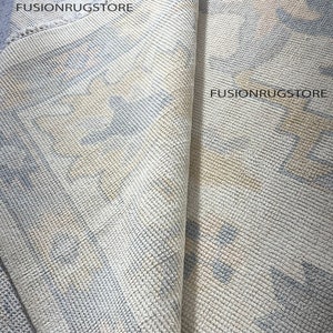 Może przedstawiać: Zbliżenie na jasnoniebieski i kremowy dywan z tekstem "Fusionrugstore" powt&oacute;rzonym trzy razy.