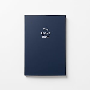 Könnte beinhalten: Ein dunkelblaues Hardcover-Buch mit dem Titel "The Cook's Book" in weiß auf dem Einband.