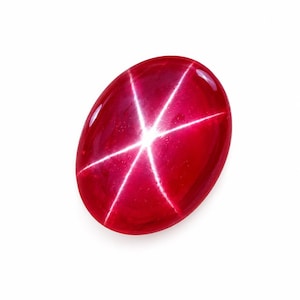 Könnte beinhalten: Ein ovaler Sternrubin-Edelstein im Cabochon-Schliff mit tiefroter Farbe und einem ausgeprägten, sechsstrahligen weißen Sternmuster, das sich in der Mitte der glatten, polierten Oberfläche befindet und das optische Phänomen Asterismus zeigt.