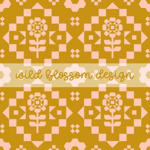 以下が含まれることがあります： ゴールドとピンクの色合いの幾何学模様。デザインは、繰り返される花柄と幾何学的な形状を特徴とし、中央には「wild blossom design」というテキストが薄いベージュのバナーで表示されています。全体的な美しさはフォークアートを彷彿とさせます。