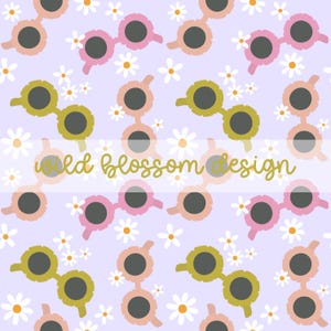 Op de afbeelding: Een naadloos patroon met roze en gele zonnebrillen met witte madeliefjes op een lichtpaarse achtergrond. De tekst "wild blossom design" is geschreven in gouden schrift.