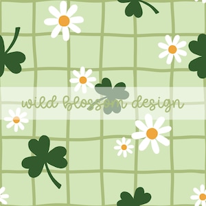 Op de afbeelding: Een naadloos patroon met witte madeliefjes en groene klavers op een lichtgroene achtergrond met een rasterpatroon. De tekst "wild blossom design" staat in een wit vak.