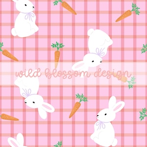 May include: A repeating pattern featuring white bunnies with lavender bows and orange carrots with green tops on a pink plaid background. The text "wild blossom design" is across the center.