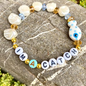 Pulsera I'm a Catch: pulsera llamativa con pez de porcelana, cuentas y frase. Hecha a mano/elástica. Regalo con divertidas cuentas con letras.