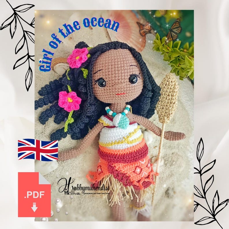 May include: A crocheted doll with dark skin, black hair, and pink flower accents. The doll wears a colorful dress and holds a staff. The text "Girl of the Ocean" is visible above the doll.