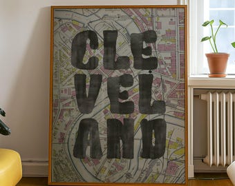 Puede incluir: Una impresión enmarcada de un mapa vintage de Cleveland, Ohio con la palabra "CLEVELAND" impresa en letras grandes y negras sobre el mapa.