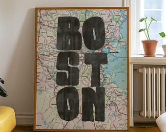 May include: A framed map of Boston with the city name boldly printed in large, black, block letters. The map features a network of roads and waterways, set against a neutral background. The frame is a warm, natural wood tone, adding a touch of elegance to the artwork.