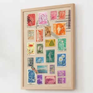 May include: A framed collage of vintage postage stamps from around the world. The stamps are arranged in a grid pattern and feature a variety of colors, designs, and subjects. The frame is made of wood and has a natural finish.
