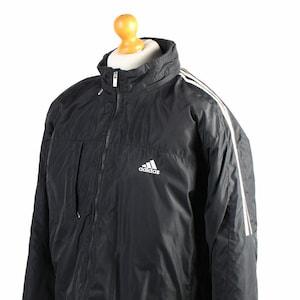 May include: Black Adidas jacket with white stripes down the sleeves and a white Adidas logo on the chest.