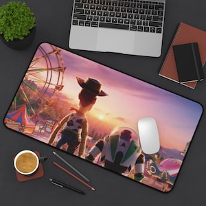 May include: A rectangular mousepad featuring a scene from the animated movie Toy Story. The design includes Woody and Buzz Lightyear in front of a Ferris wheel at sunset. A white computer mouse is on the pad.