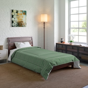 May include: A bed with a dark wooden frame and a green and white checkered comforter. A white pillow rests on the bed. A painting with circular designs hangs on the white brick wall. A floor lamp and a window are also visible.
