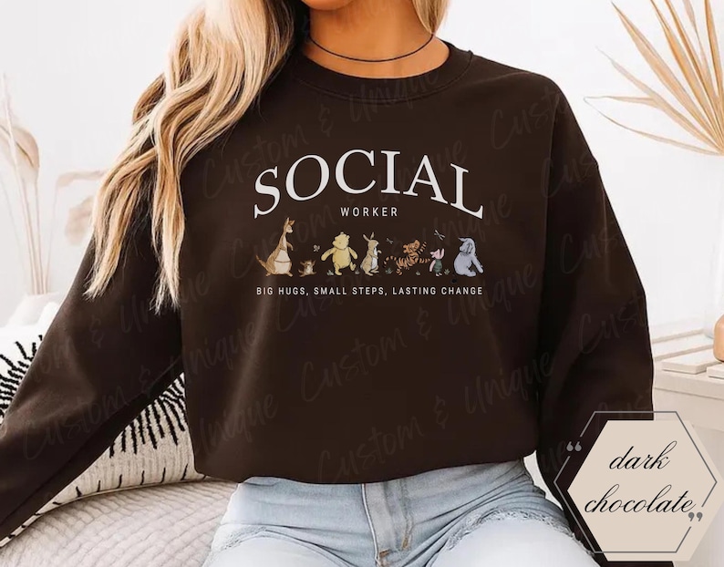 Pu&ograve; includere: Felpa color cioccolato fondente con la scritta bianca "SOCIAL WORKER". Sotto il testo ci sono personaggi dei cartoni animati. La felpa ha anche la scritta "BIG HUGS, SMALL STEPS, LASTING CHANGE".