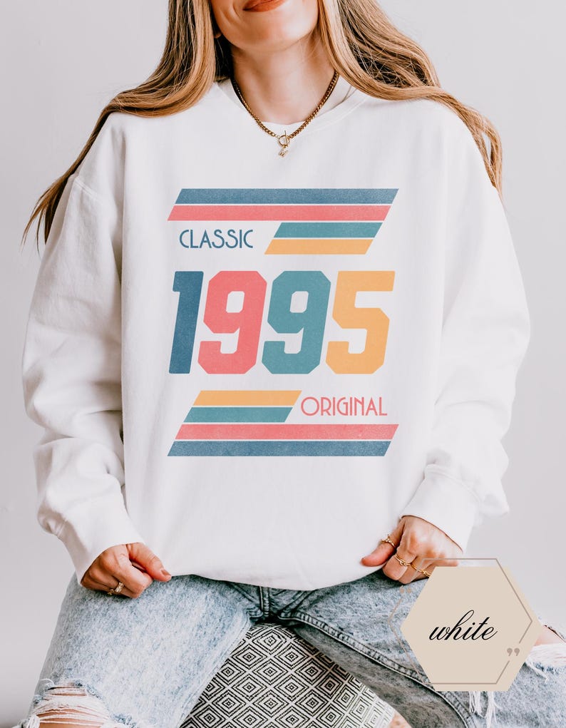 May include: White sweatshirt with a retro design featuring the year 1995 in colorful block letters and the words "Classic" and "Original" in black text.