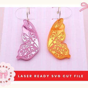 Puede incluir: Dos pendientes de alas de mariposa, uno rosa y otro dorado, con intrincados diseños de filigrana. Los pendientes cuelgan de aros dorados. La imagen también incluye el texto "LASER READY SVG CUT FILE".