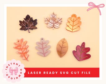 Pode incluir: Uma coleção de formas de folhas cortadas a laser em várias cores, incluindo castanho, dourado e rosa. As folhas estão dispostas sobre um fundo laranja claro. O texto na parte inferior diz "LASER READY SVG CUT FILE".