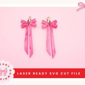 Op de afbeelding: Een paar roze strikvormige oorbellen met lange, bungelende linten. De oorbellen hebben goudkleurige hoepels en staan tegen een roze achtergrond. De tekst "LASER READY SVG CUT FILE" staat in het rood. Een roze strik-afbeelding staat in de hoek.
