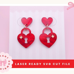 Peut inclure: Deux boucles d'oreilles rouges en forme de cœur avec un motif de cadenas et un trou de serrure. Les boucles d'oreilles ont un petit cœur en haut et un anneau doré reliant les deux cœurs. Le texte "LASER READY SVG CUT FILE" est visible.