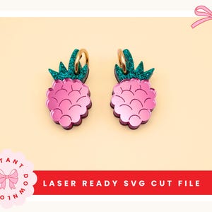 Puede incluir: Un par de pendientes de piña rosas con aros dorados y copas verdes brillantes. Los pendientes están cortados con láser y presentan el texto "LASER READY SVG CUT FILE". Un accesorio divertido y juguetón.