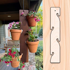 May include: A wooden vertical planter with three terracotta pots filled with flowering plants. The planter is suspended from a black cord. A separate, unfinished wooden hanging bracket with three hooks is shown on the right.