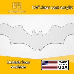 May include: A clear 1/4 inch thick acrylic bat cutout. The bat is a simple silhouette with wings spread wide. The text "1/4" clear cast acrylic" and "Stedreddoowls co" are visible at the top of the image. The text "Multiple Sizes Available" is at the bottom left of the image. A small American flag is at the bottom center of the image. The text "MADE IN THE USA" is at the bottom right of the image.