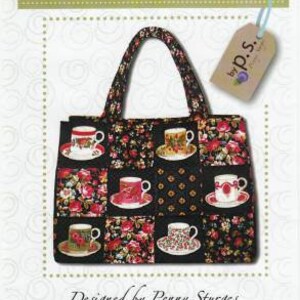 May include: A black and white fabric tote bag with a floral pattern and teacup designs. The bag has a black handle and a label that says "Quilts Illustrated by P.S.". The text "ps024 Chubby Charmer" is also visible on the image.