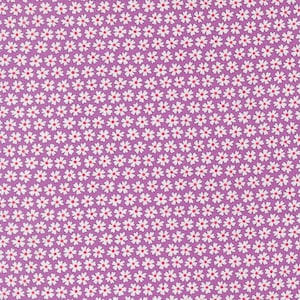 May include: Close-up of a fabric with a repeating floral pattern. The design features small white flowers with red centers on a purple background. The fabric is densely covered with the floral motif.