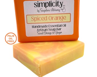 Puede incluir: Una barra de jabón artesanal naranja y amarillo con las palabras "Spiced Orange" y "Handmade Essential Oil Artisan Soap Bar Sweet Orange & Ginger" en la etiqueta. La etiqueta está sobre un fondo naranja brillante. El jabón es libre de aceite de palma.
