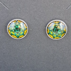 May include: A pair of silver stud earrings with green and yellow patterned glass inserts.