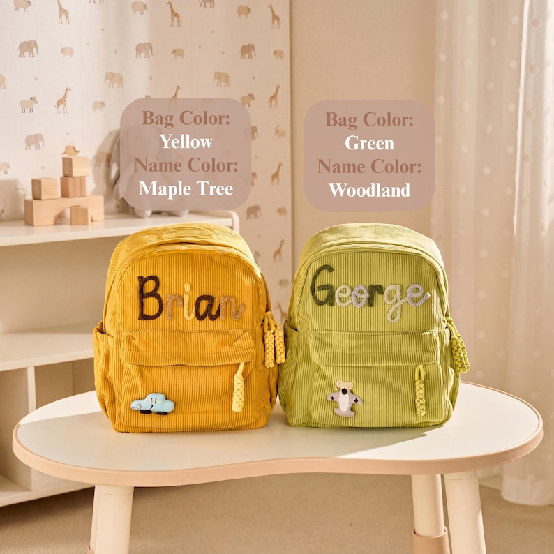 May include: Two corduroy backpacks, one yellow and one green, each featuring a front pocket, a zip pull, and a name embroidered on the front. The yellow bag displays the name Brian and a car patch, while the green bag shows George and a plane.