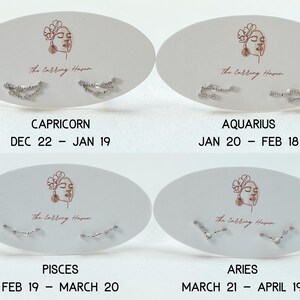 May include: Four pairs of silver stud earrings, each presented on an oval card with a zodiac sign and dates. The cards feature a line drawing of a woman's face and the text "The Calling Haven". The signs are Capricorn, Aquarius, Pisces, and Aries.